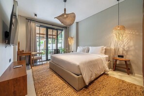 A modern bedroom with a large bed, a desk, and a TV. - Cozy 3BR Villa in Lush Ubud w Pool, Patio & Garden (Gianyar Regency)