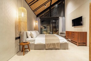 A modern bedroom with a large bed, a TV mounted on the wall, and a wooden cabinet. - Badung's 2BR Gem w Private Pool & Beach Nearby (Badung Regency)