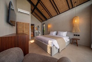 Een moderne slaapkamer met een groot bed, een houten bureau en een plafond met een lamp van natuurlijk materiaal.