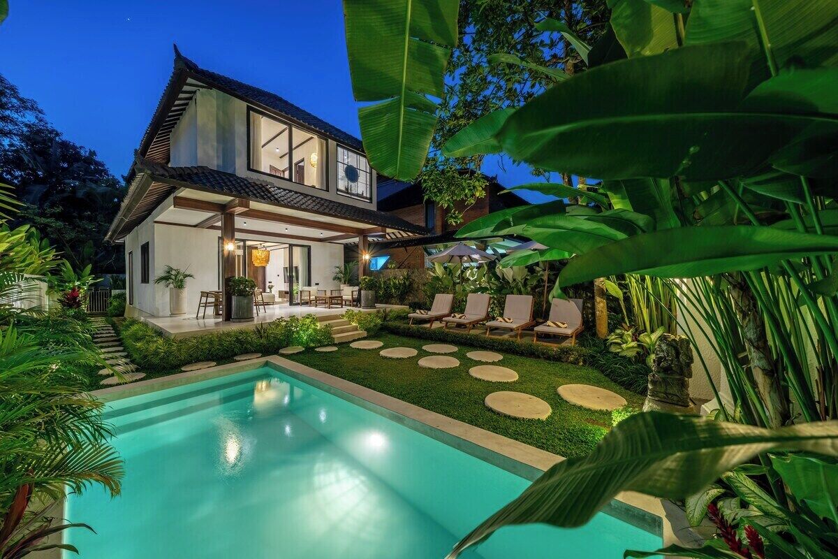 A modern house with a swimming pool, surrounded by lush greenery and a well-maintained garden.