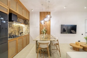 A modern kitchen with a marble countertop, wooden cabinets, and a built-in stove. - Brand New Chic 2BR Villa, Beach Access, South Kuta (South Kuta)