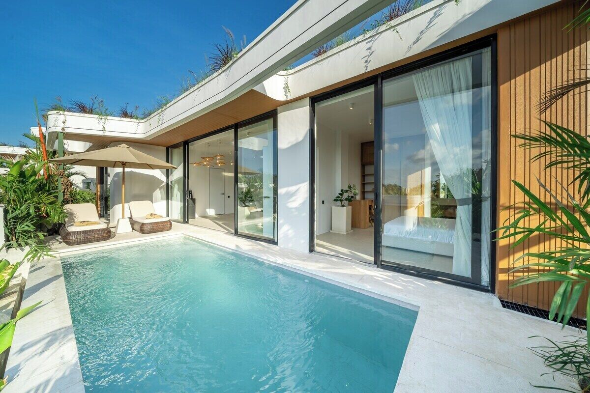 A modern house with a swimming pool, sliding glass doors, and outdoor seating.