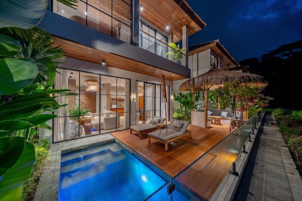 A modern house with a swimming pool, outdoor seating, and a thatched roof structure. - Tropical 2BR in Ubud's Ricefields w Pool & Garden (Tegallalang)