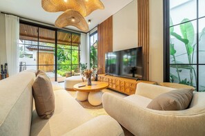 Un salon moderne avec un canapé, une table basse et un téléviseur.