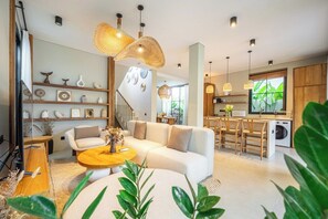 Un salon moderne avec un canapé, une table basse et des objets décoratifs disposés sur des étagères.