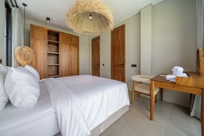 A hotel room with a large bed, wooden wardrobe, a dining table, and a hanging light fixture. - Tranquil 2BR Villa in Ubud • Pool • Patio • Garden (Gianyar Regency)