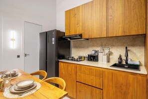 A compact kitchen with wooden cabinets, a built-in microwave, and a sink. - New Jungle 3BR Villa+Beach Access+Huge Pool 10A (South Kuta)