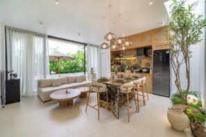 Une cuisine moderne dotée d’un îlot en marbre, de meubles en bois et d’un four encastré.