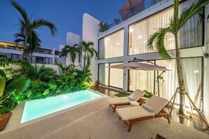 A modern outdoor pool area with lounge chairs and palm trees. - Brand NEW villa near the beach | Large pool | 2BDR (Badung Regency)