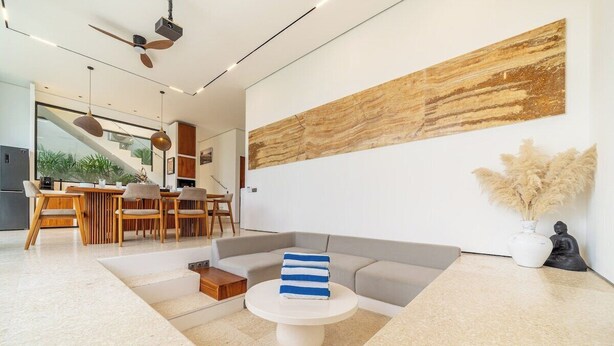 Una sala de estar moderna con un sofá, una mesa de centro y un comedor con sillas y una mesa.