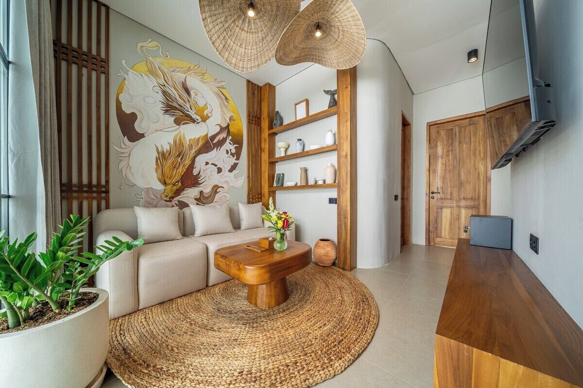 A modern living room with a sofa, coffee table, and a large wall mural.