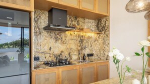 Una cocina moderna con salpicadero de piedra, armarios de madera y cocina a gas.