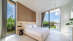 Un dormitorio moderno con una cama grande, cabecera de madera y vista a zonas verdes.