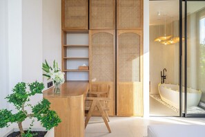 Ein modernes Badezimmer mit einer freistehenden Badewanne, einem Holzbadezimmermöbel mit Spiegel und einem Rattierfachwerk.