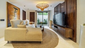 Uma sala de estar moderna com sofá, televisão e obras de arte na parede.