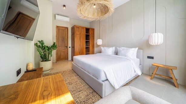 Una camera da letto moderna con un letto, un armadio in legno e un tavolo da pranzo.
