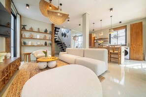 Ein modernes Wohnzimmer mit einer Couch, einem Couchtisch und einem Bücherregal.