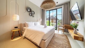A modern hotel room with a large bed, a TV, and a view of the outdoors. - Tropical 2BR Villa w Private Pool & Garden • Ubud (Gianyar Regency)