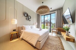 Ein modernes Hotelzimmer mit einem großen Bett, einem Fernseher und Blick ins Freie.