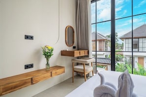Hotelkamer met een bed, een houten console, een spiegel, een stoel en een raam met uitzicht op gebouwen.