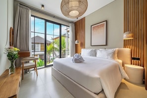 Ein modernes Hotelzimmer mit einem großen Bett, einem Schreibtisch und Blick ins Freie.