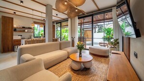 A modern living room with a sofa, a round coffee table, and a wooden side table. - Tropical 2BR Villa w Private Pool & Garden • Ubud (Gianyar Regency)