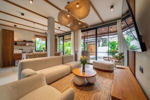 Ein modernes Wohnzimmer mit einer Couch, einem runden Couchtisch und einem Holznachttisch.