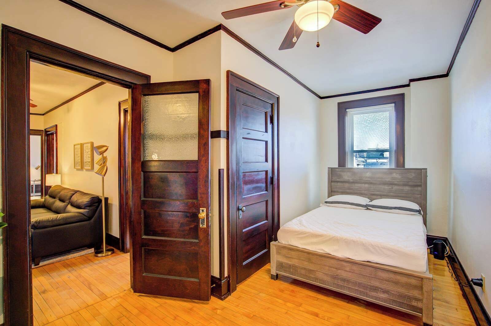 This bedroom offers a queen-sized bed, natural light, and timeless wood trim—perfect for steady routines, long stays, and a peaceful night’s sleep.