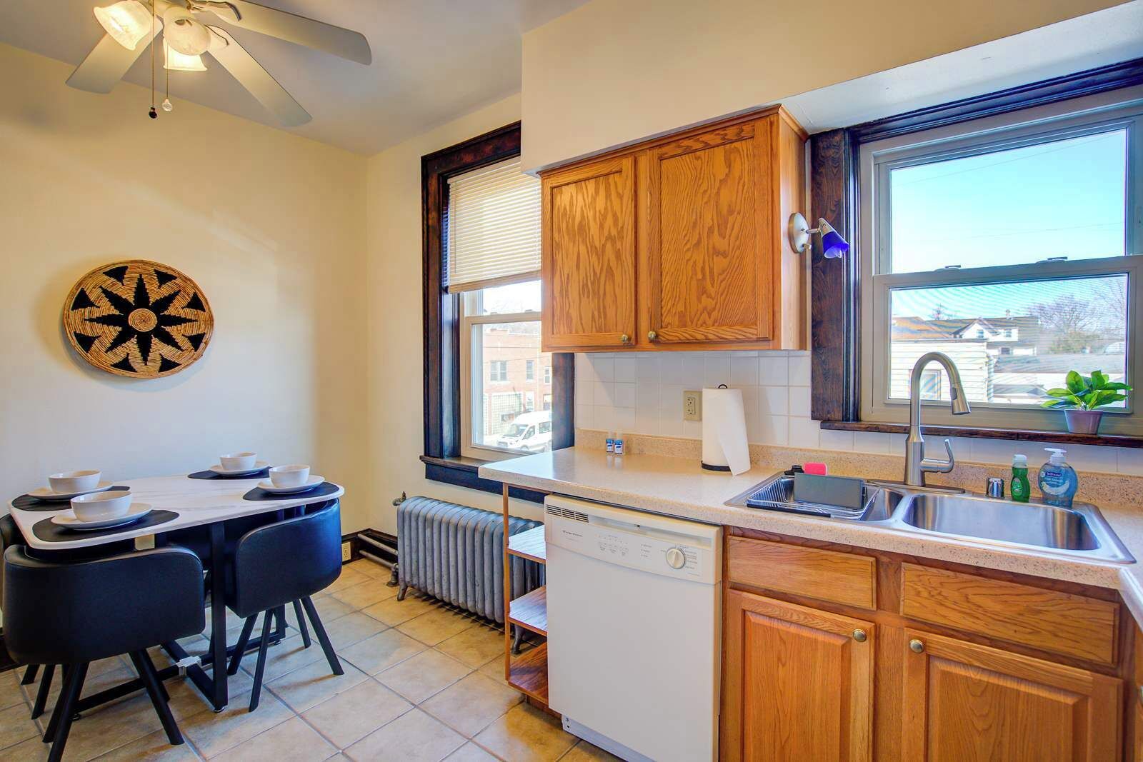 This kitchen is designed with practicality in mind, featuring a full dishwasher, double sink, and counter space for meal prep. The adjacent dining table for four makes it easy to enjoy meals at home during longer stays.