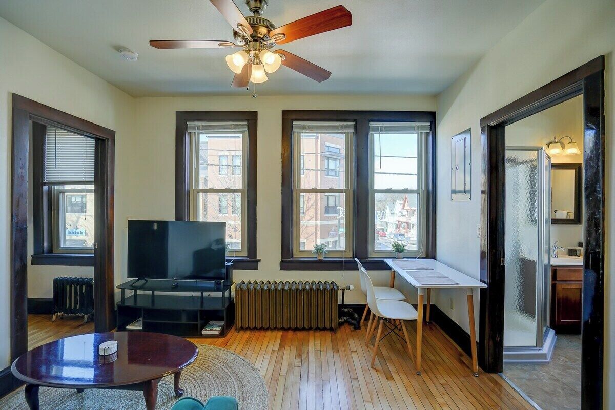 Living room with sofa, entertainment center and workspace facing Willy St