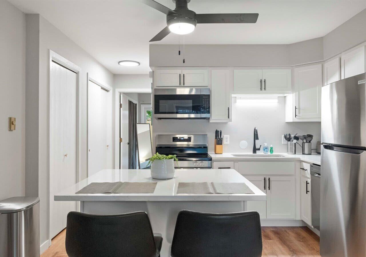Sleek, modern kitchen featuring stainless steel appliances, quartz countertops, and a convenient island with seating—perfect for cooking, dining, or entertaining in comfort.