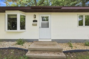 A single-story house with a front door, a mailbox, and a small garden area with pebbles and plants. - Madison Home with Parking, Washer & Dryer (Madison)