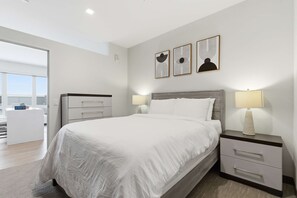 A modern bedroom with a bed, bedside tables, and artwork on the wall. - Near MCW | Free Parking & In-Unit Laundry (Milwaukee)
