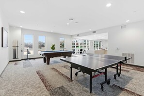 Ein geräumiger Raum mit Billardtisch, Tischtennistisch und Poolbillardtisch.