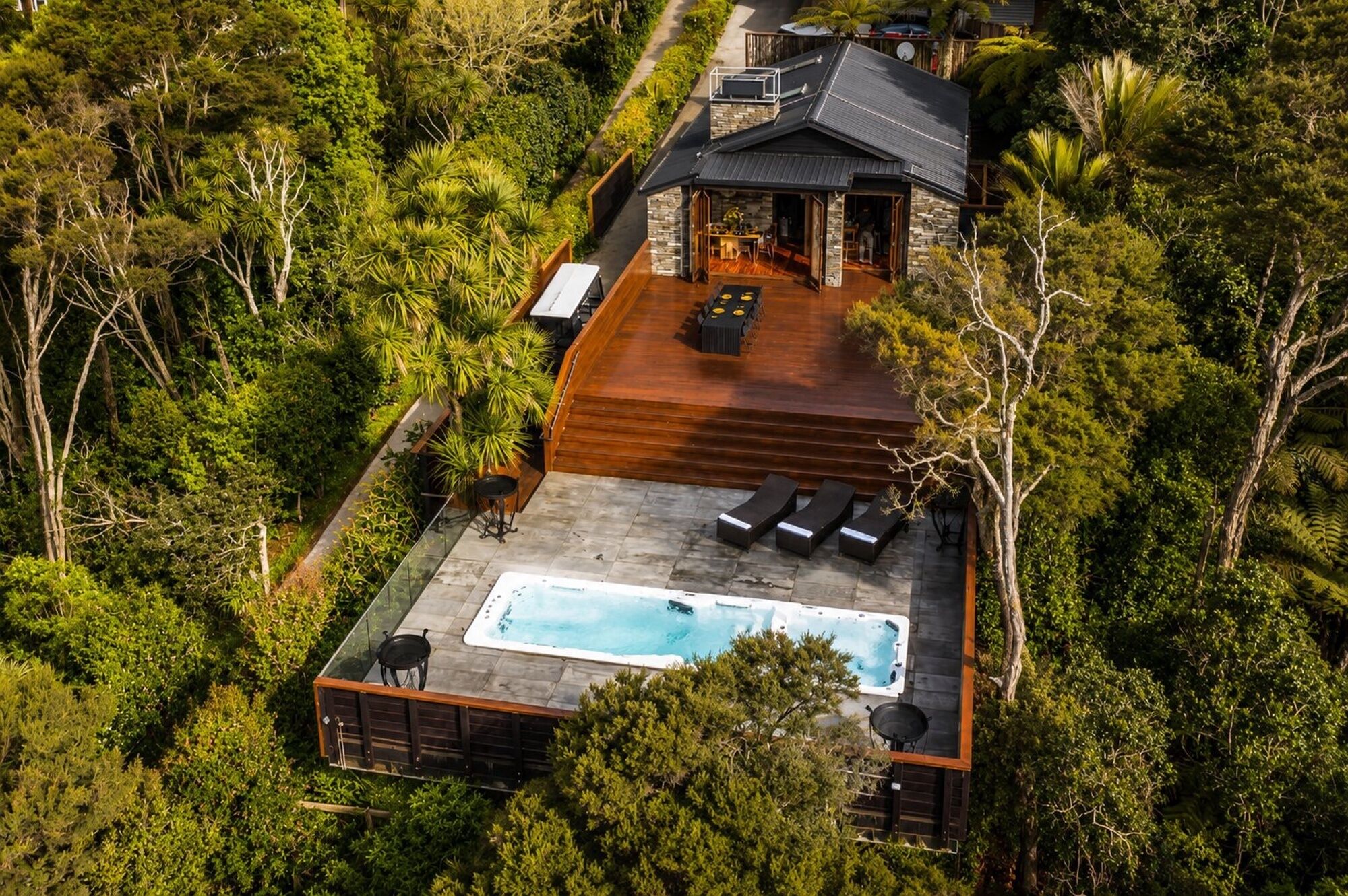 Vue aérienne d’une maison dotée d’une piscine, d’une terrasse et entourée d’une végétation luxuriante.