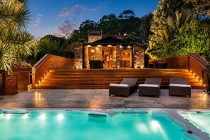 A pool area with a hot tub, wooden deck, and lounge chairs. - Maison Blanc Lodge - Nature Haven 4-Bed Luxury (Auckland)