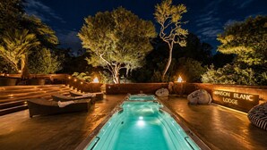 Ein Poolbereich mit Whirlpools, Liegestühlen und einer Holzterrasse.