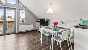 Ett modernt kök med matplats, TV och utsikt över omgivningarna.
