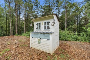 Eine kleine Holzhütte mit zwei Fenstern, einer Tür und einem Willkommensschild.