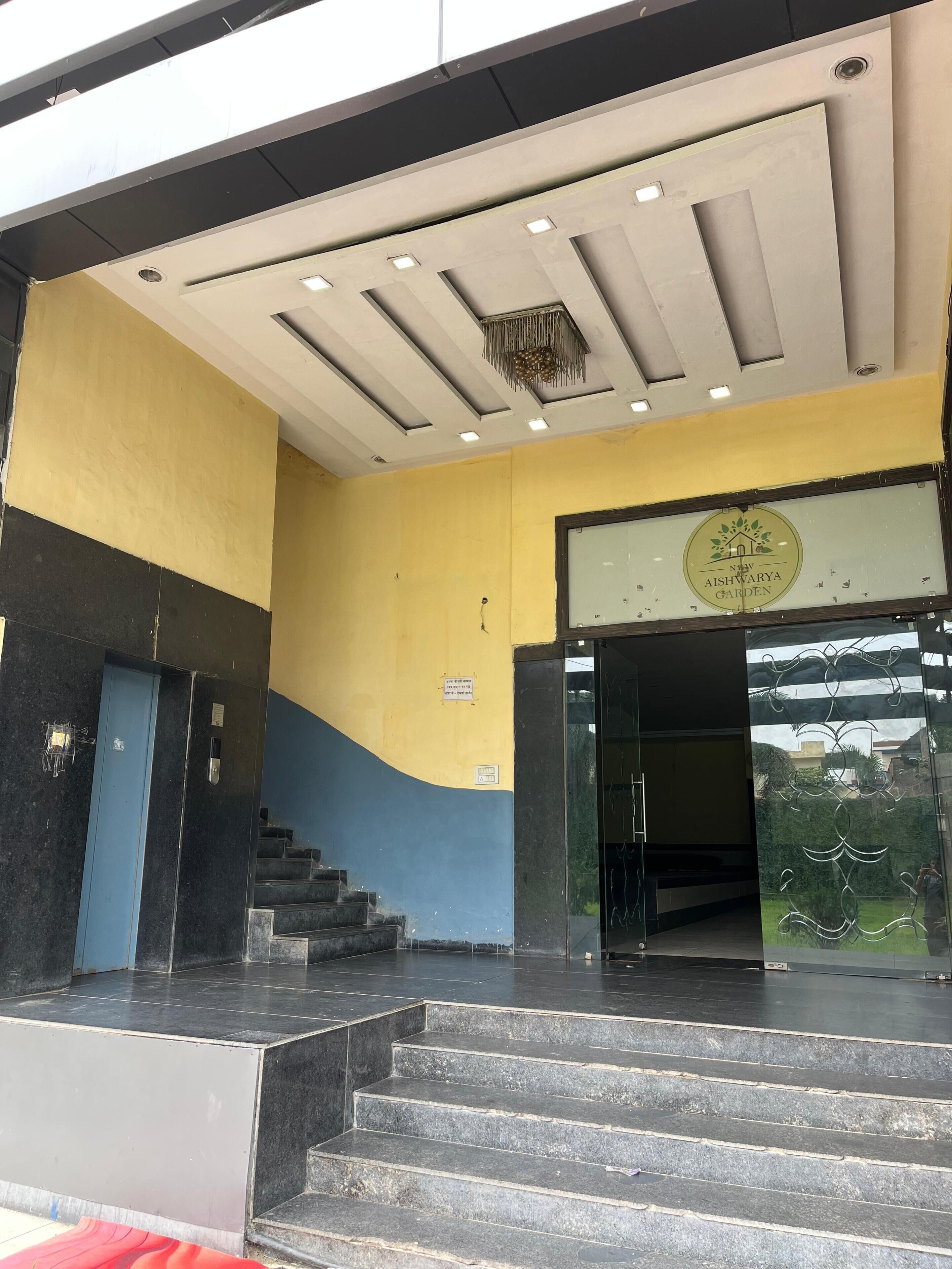 A building entrance with a sign for 'New Aishwarya Garden.'