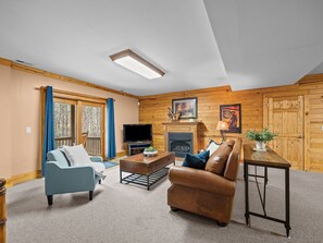 A living room with a fireplace, a television, and a sofa. - Caribou Lodge at Lake Lure (Lake Lure)