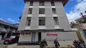 A multi-story building with a flat roof and a sign for 'Just Rooms' indicating it is a lodging establishment. - Just Rooms (Chikkamagaluru)