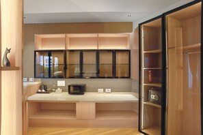 Eine moderne Küche mit eingebauter Mikrowelle, einer Kaffeemaschine und einem kleinen Kühlschrank.