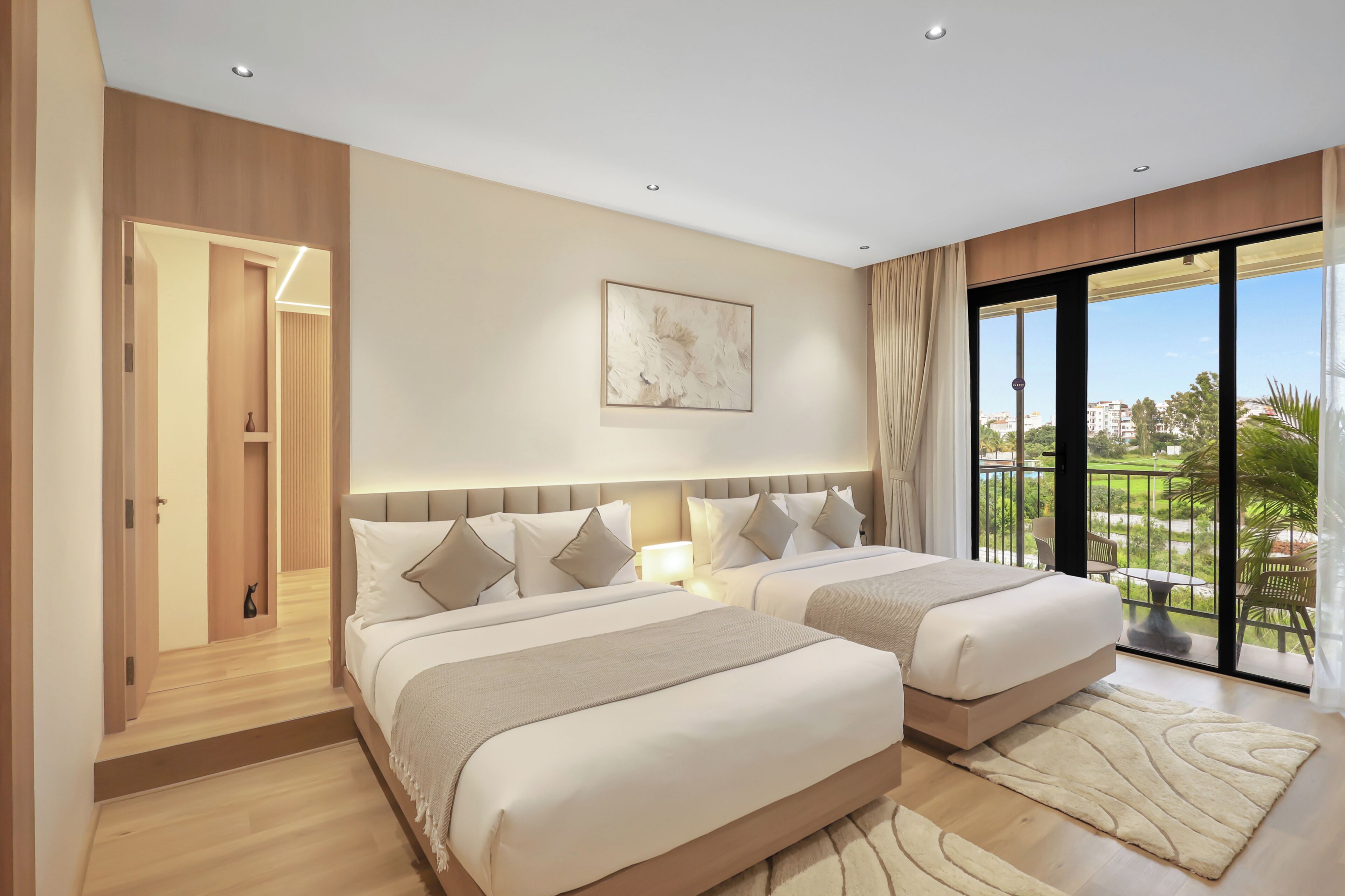 Habitación de hotel con dos camas, un ventanal grande y vistas al exterior.