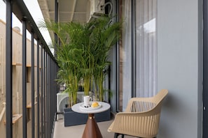 Ein Balkon mit Tisch, Stuhl und einer Topfpflanze.