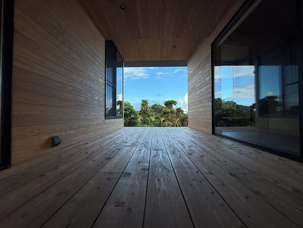 A modern interior with wooden flooring and large glass windows.