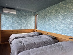Una camera con un letto a castello, una finestra e un muro decorato.