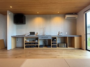 A modern kitchen with wooden cabinets, a built-in microwave, and a large window.
