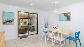 A dining area with a table, chairs, and artwork on the walls.