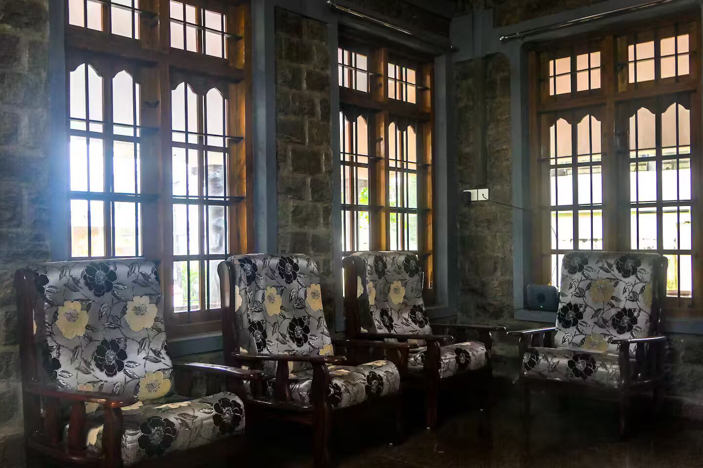 Quatro cadeiras estofadas com padrão floral, dispostas em linha.